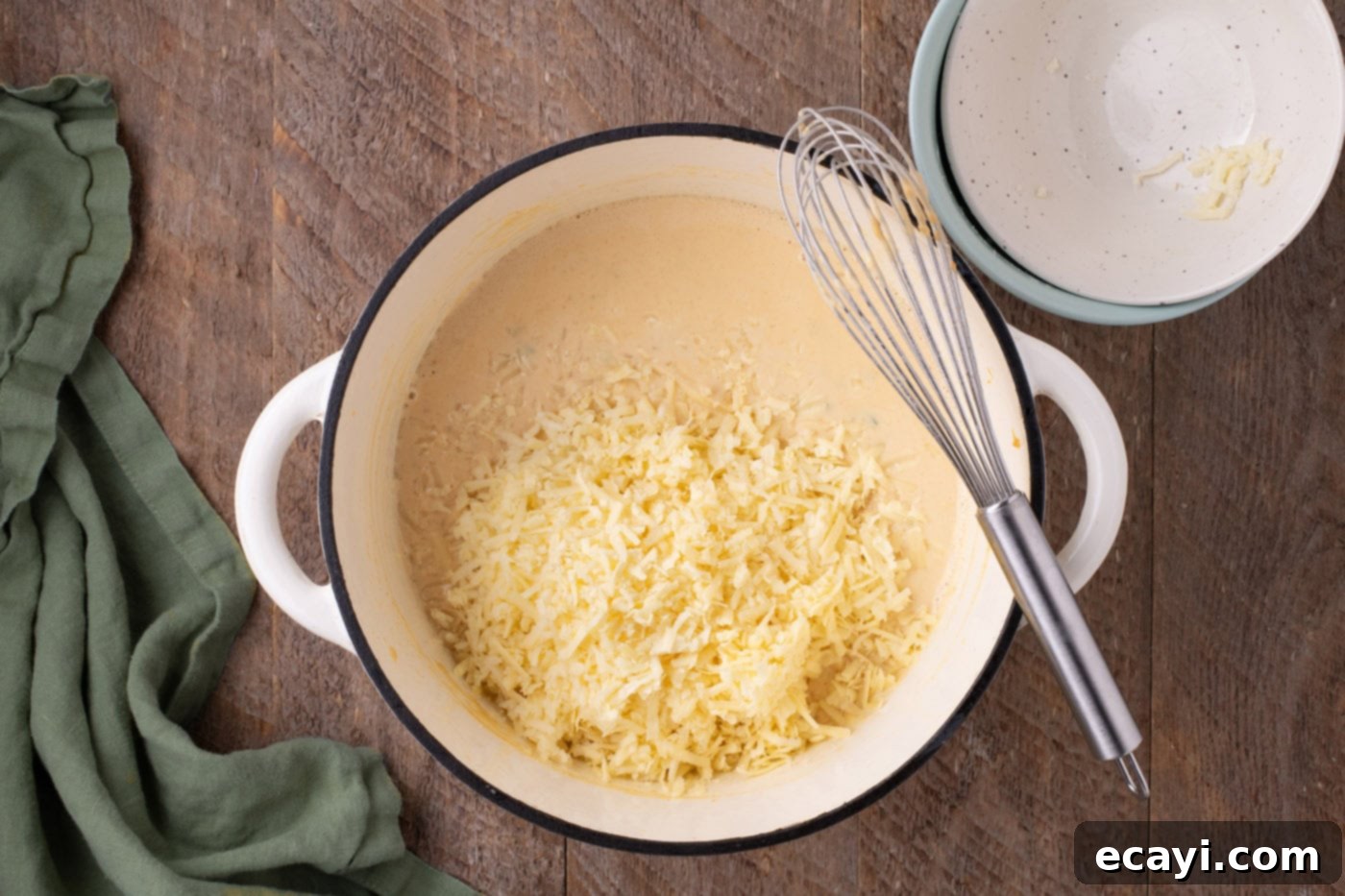 Spicy Cheesy Popper Mac 9 cheese added to jalapeno mixture in a pot