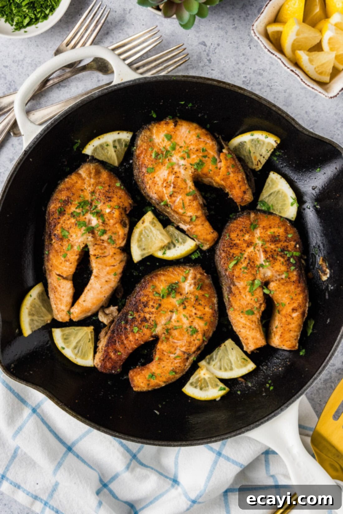 The Art of Perfect Salmon Steaks 3 A cast iron skillet filled with beautifully seared Salmon Steaks and bright lemon wedges, ready to be lifted off the heat.