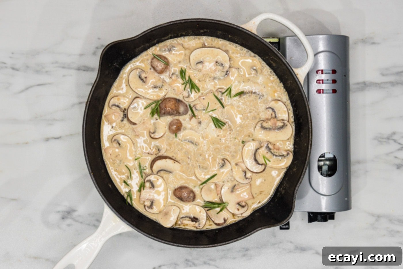 Delicate Veal Cutlets 7 creamy scallopini sauce simmering in a skillet with sliced mushrooms and fresh rosemary