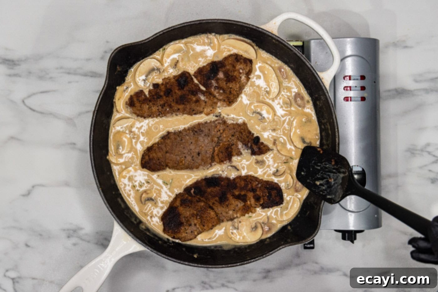 Delicate Veal Cutlets 8 veal cutlets covered in cream and mushroom sauce in a skillet, ready to serve