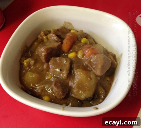 Homestyle Beef Biscuit Pot Pie 7 A delicious beef stew, brimming with tender chunks of beef, potatoes, carrots, and mushrooms, simmering gently in a large pot, ready for the next stage of cooking.