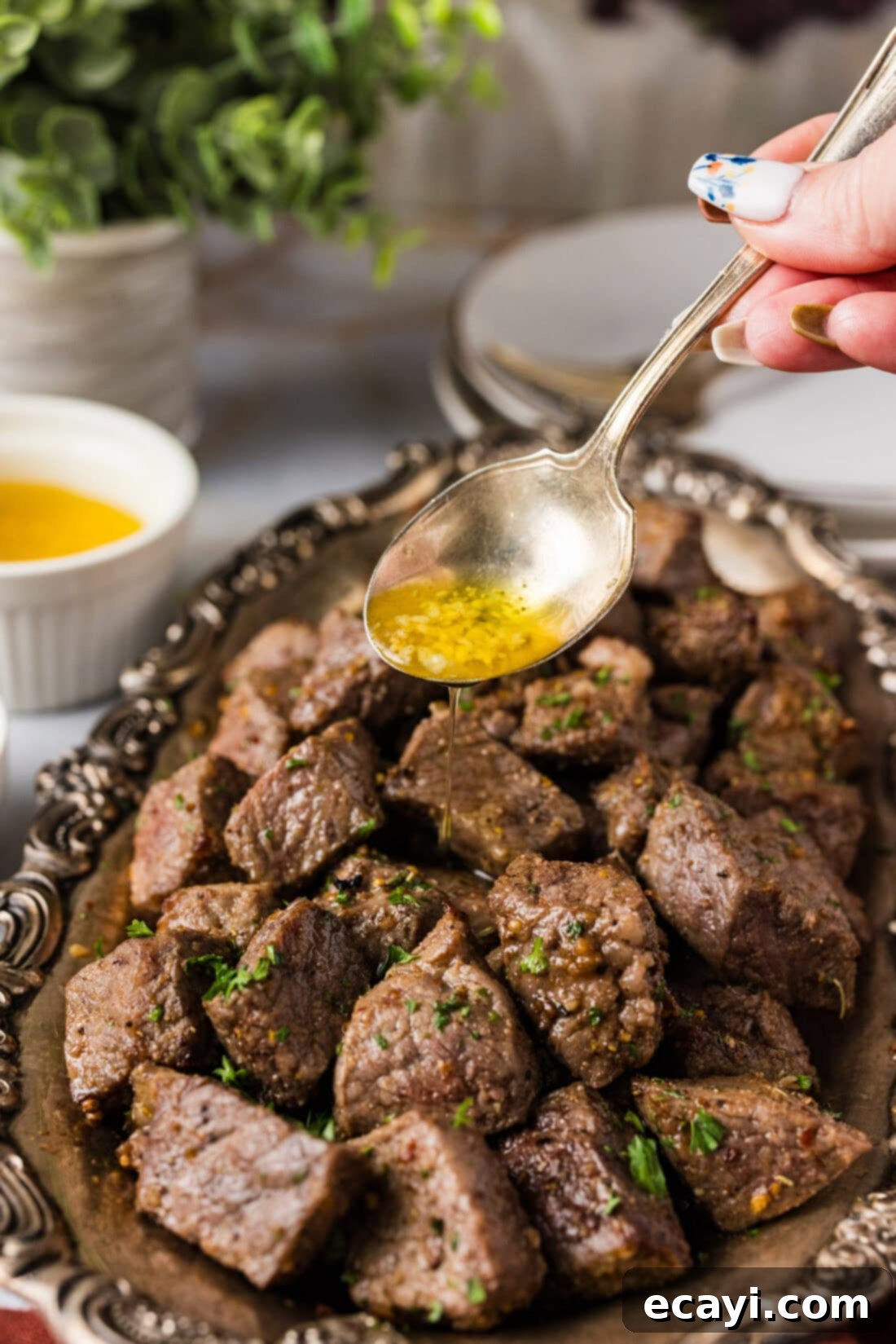 Ultimate Air Fryer Steak Bites 3 Garlic butter being drizzled over Air Fryer Steak Bites