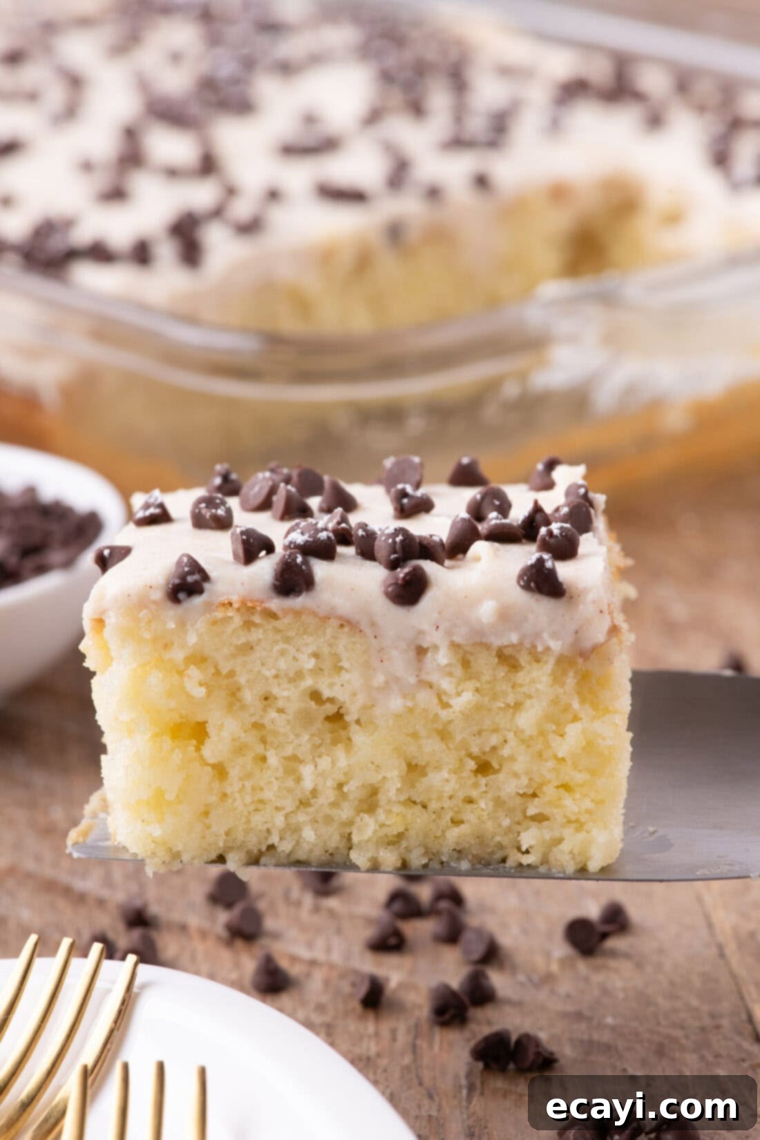 Creamy Ricotta Cannoli Poke Cake 3 A perfectly sliced piece of Cannoli Poke Cake on a spatula, showcasing its moist layers and creamy topping.