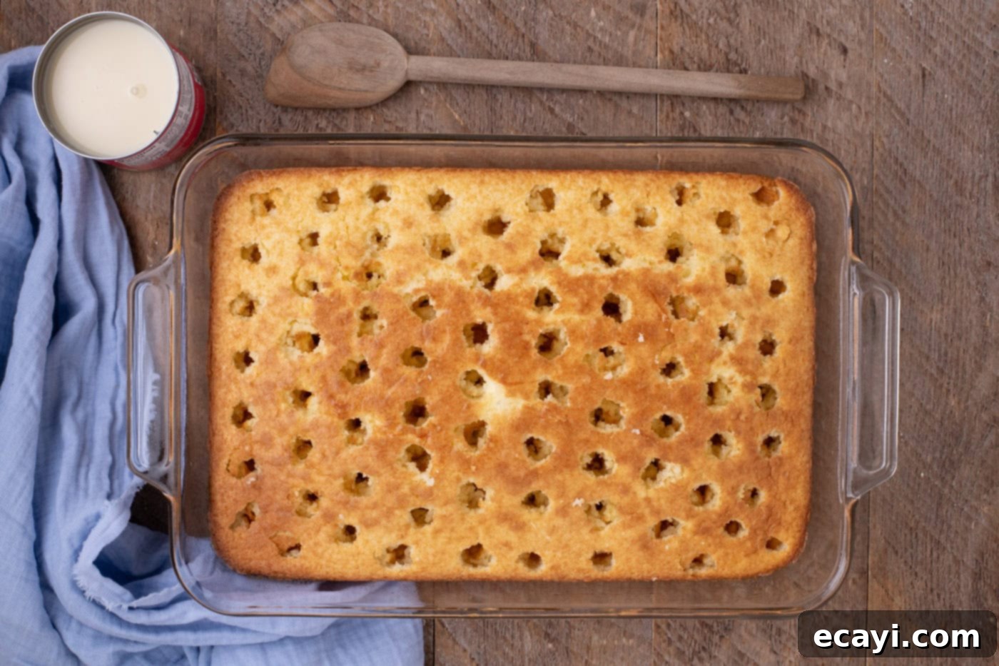Creamy Ricotta Cannoli Poke Cake 7 Freshly baked cake with holes poked into its surface