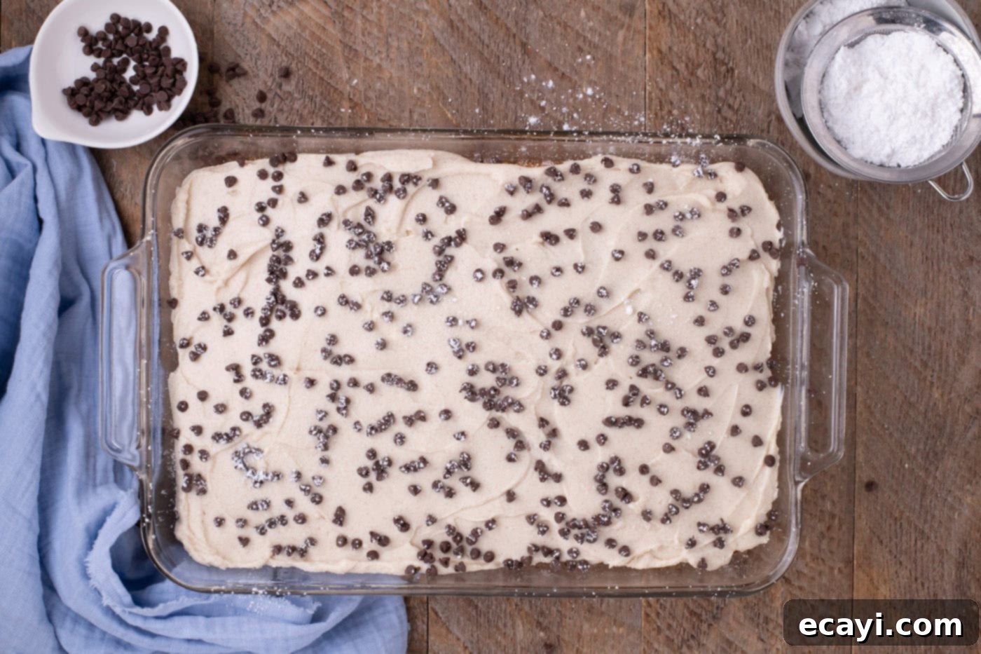 Creamy Ricotta Cannoli Poke Cake 9 Mini chocolate chips and powdered sugar topping a finished Cannoli Poke Cake