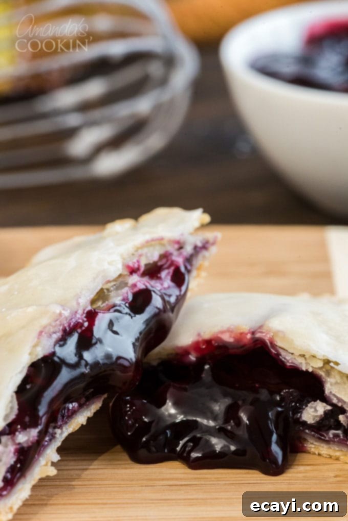 Making blueberry hand pies is fun and easy, and using a refrigerator pie crust dough cuts down on the work. Mini blueberry pies are delicious! hand pie broken in half with blueberry filling coming out