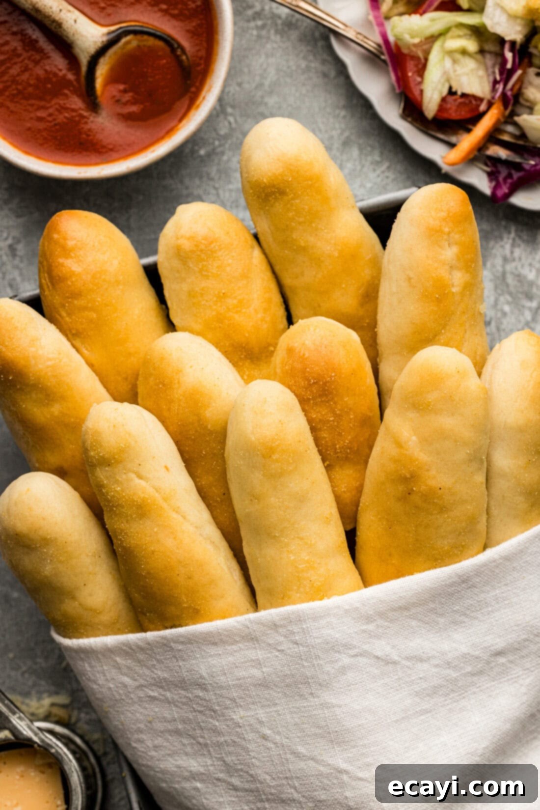 Endless Warm Garlic Breadsticks 2 Overhead photo of fluffy homemade Olive Garden Breadsticks wrapped in a towel, ready to be served.
