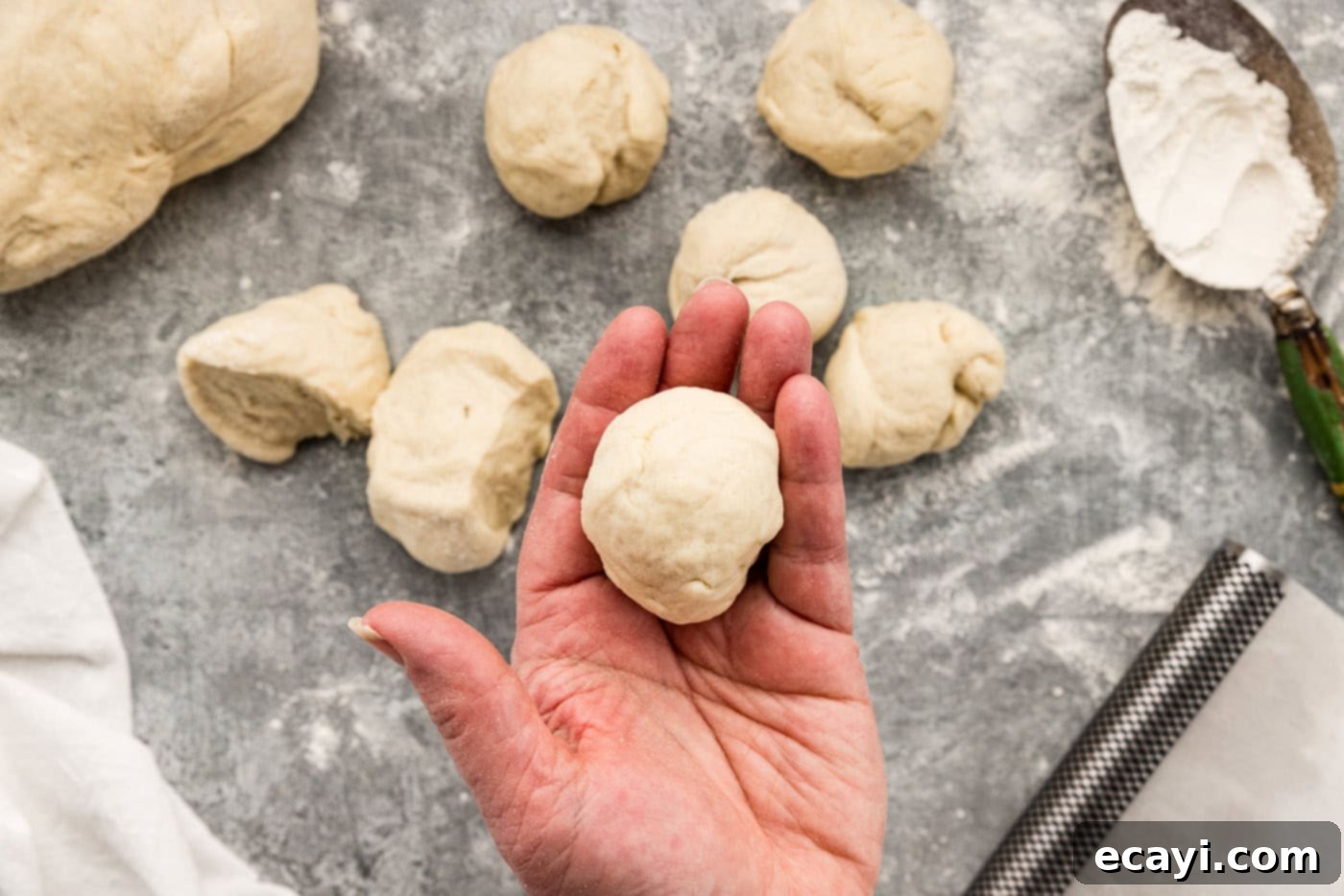 Endless Warm Garlic Breadsticks 12 A small portion of dough rolled into a perfect ball in a hand, prior to shaping into a breadstick.