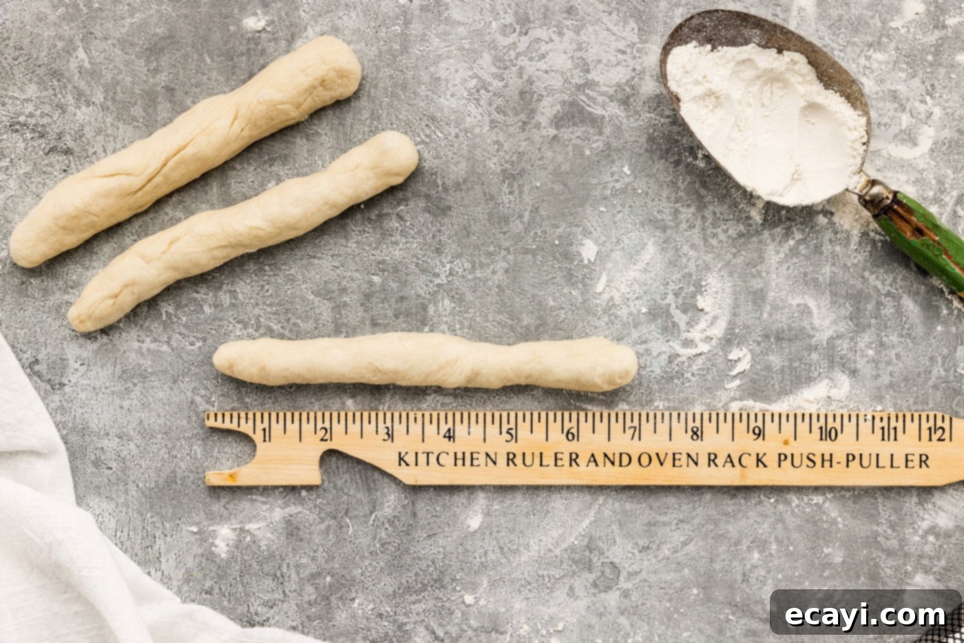 Endless Warm Garlic Breadsticks 13 A 7-inch long dough log, precisely measured with a ruler, representing the ideal breadstick shape.