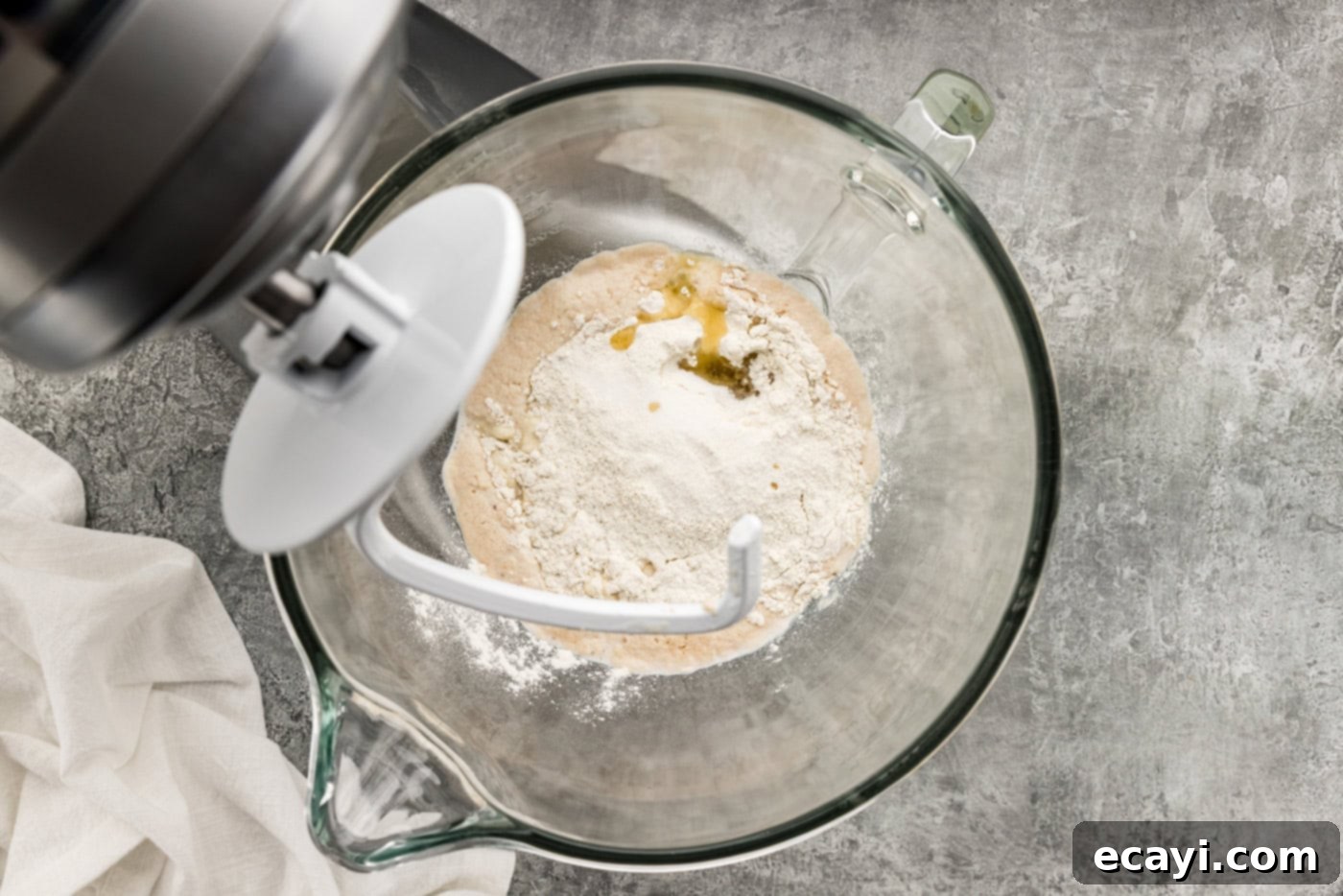Endless Warm Garlic Breadsticks 7 Dough ingredients being mixed in a stand mixer bowl with a dough hook, illustrating the mixing process.