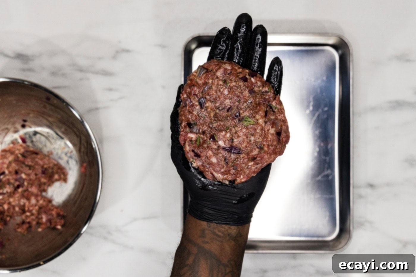 Crafted Lamb Burgers 7 A gloved hand expertly holding a freshly formed lamb burger patty, showcasing its even thickness