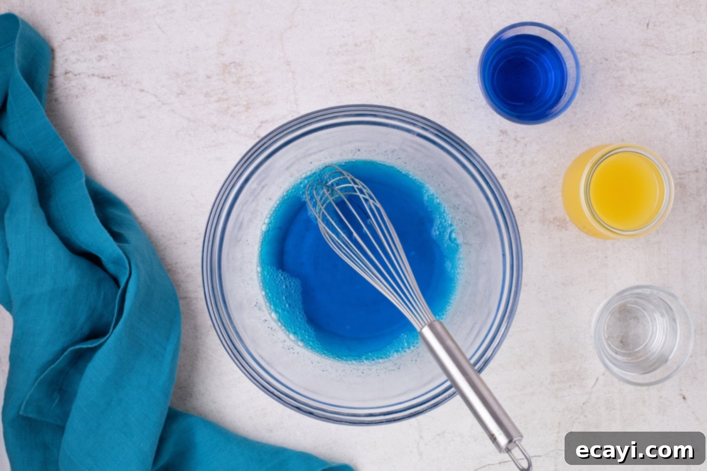 Blue Lagoon Jello Shooters 5 Whisk in a bowl with water and blue jello mixture