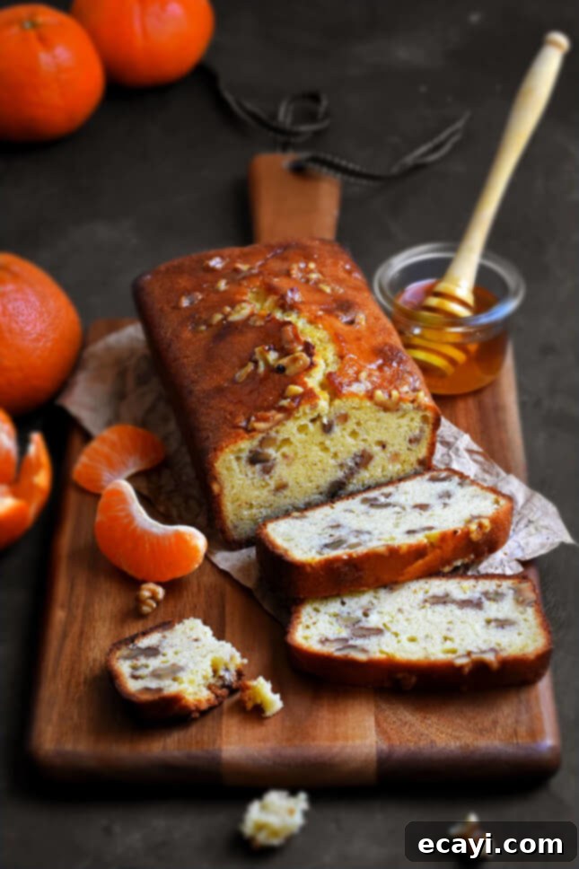 Honey-Kissed Tangerine Walnut Cake 2 Rustic Tangerine, Honey, and Walnut Cake on a wooden board, garnished with fresh tangerines and walnuts, by Pardon Your French // FoodNouveau.com