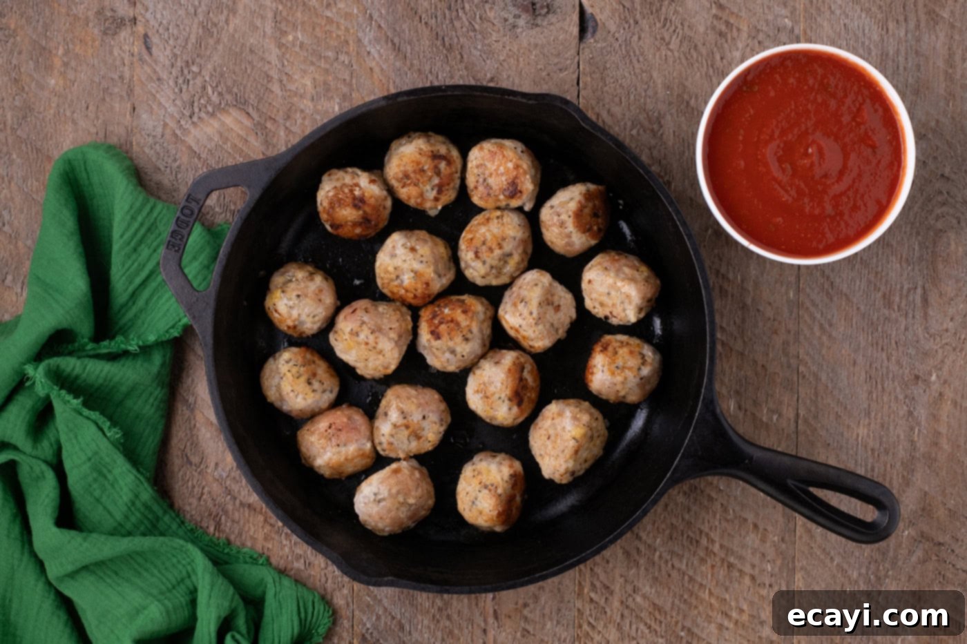 Cheesy Chicken Parm Bites 8 chicken meatballs browned in a cast iron skillet