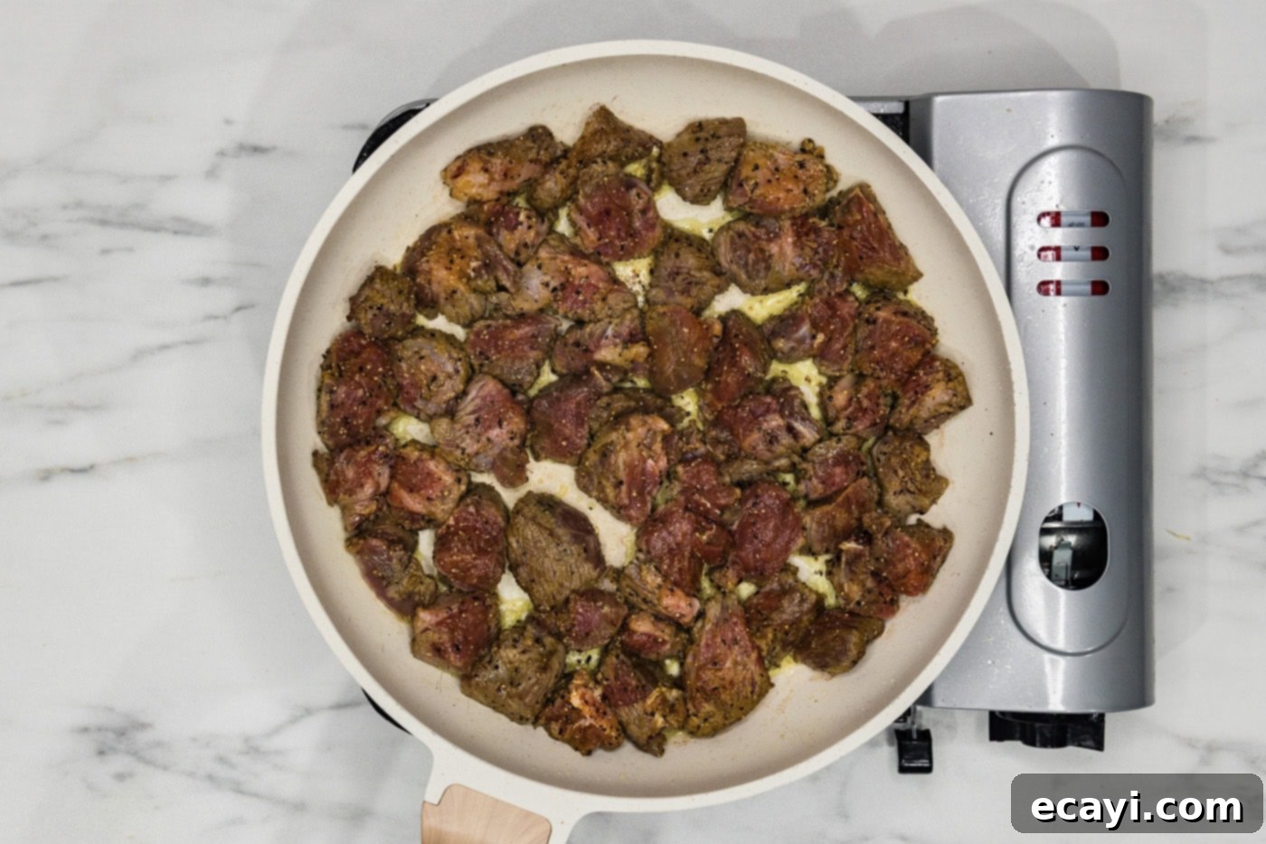 Tender Beef Curry 6 Beef cubes searing in a hot skillet, developing a rich brown crust