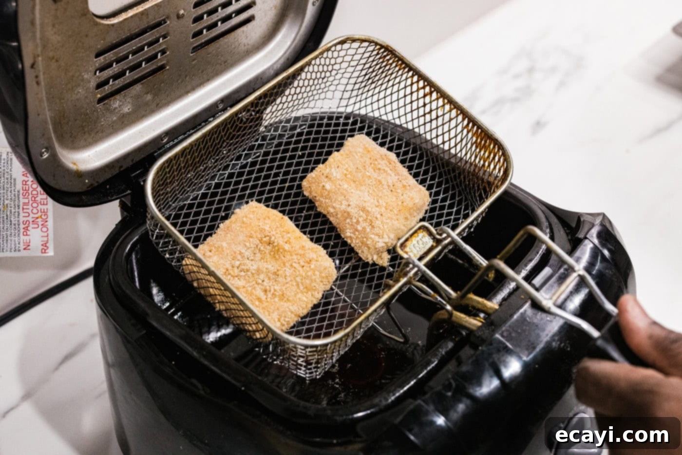 Crispy Fish Sliders 7 dredged cod patties in a deep fryer basket