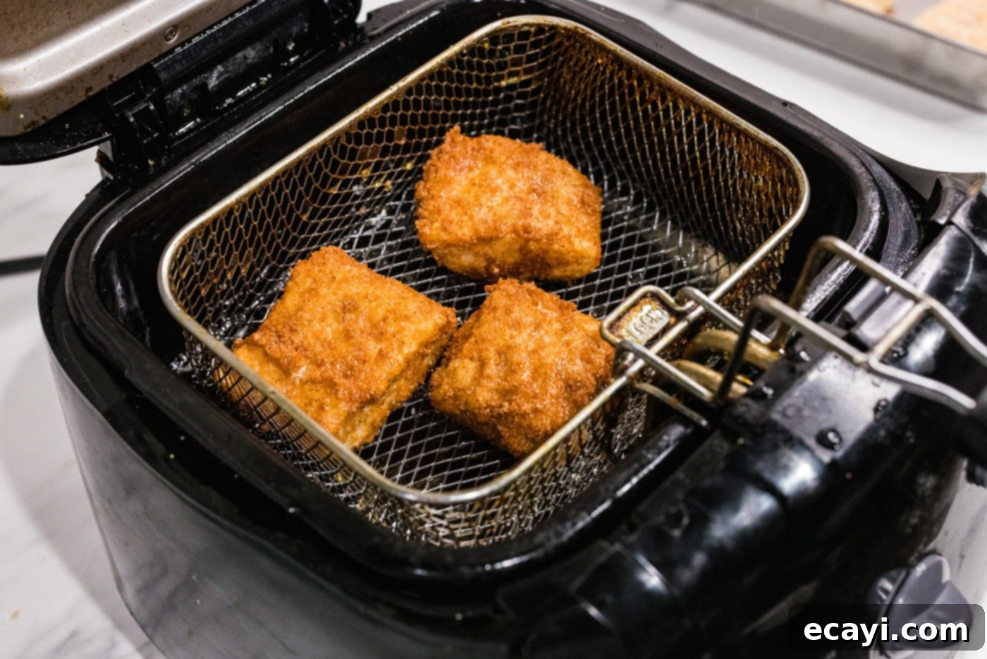 Crispy Fish Sliders 8 cooked cod patties in a deep fryer basket