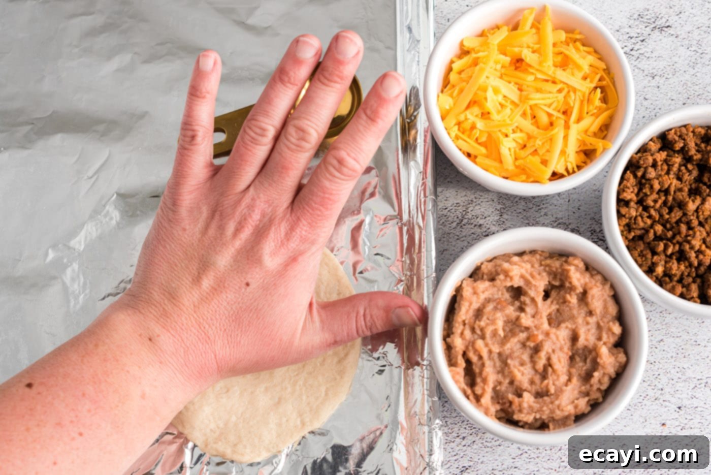 Crispy Taco Turnovers 5 flattening refrigerator dough on foil for empanadas