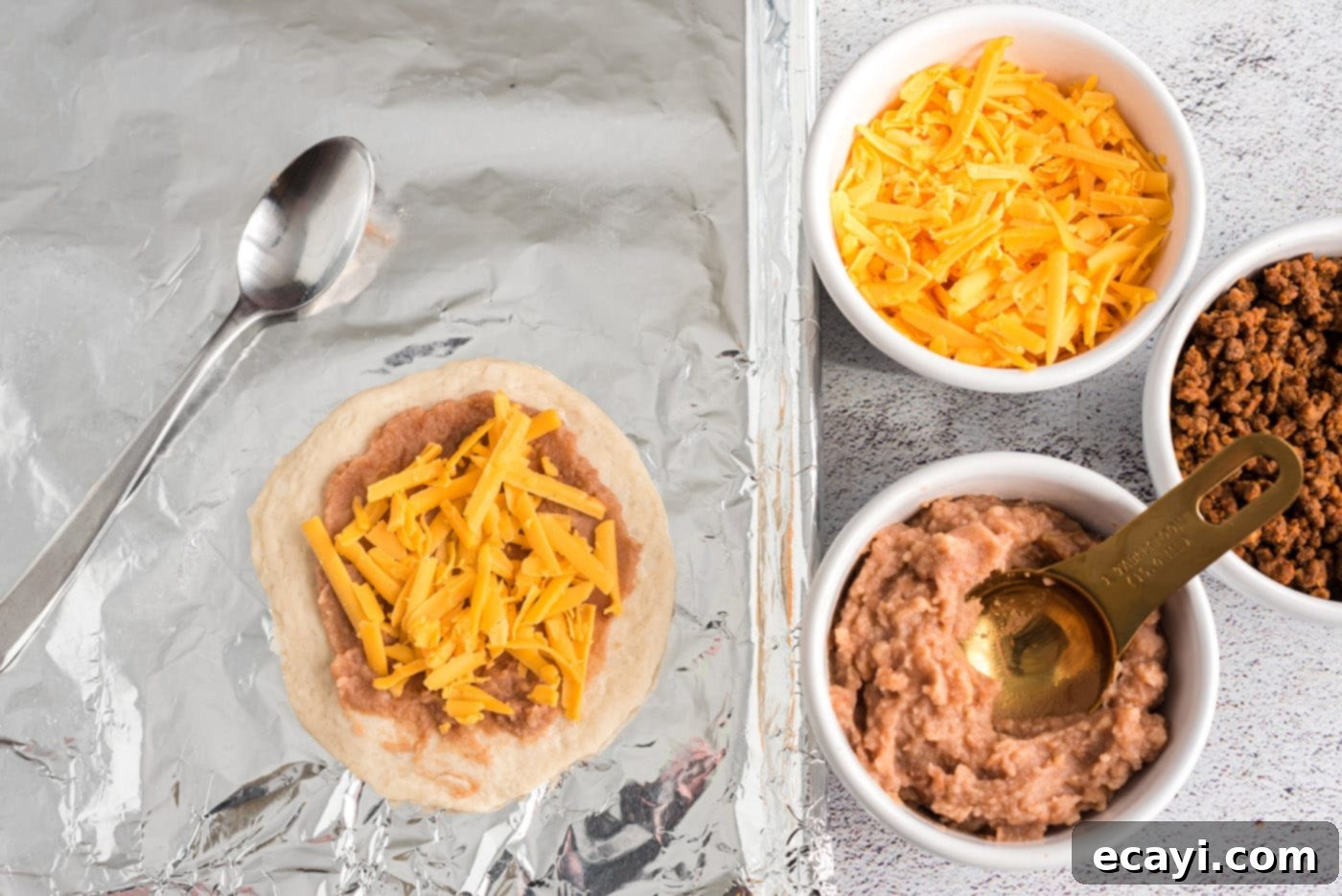 Crispy Taco Turnovers 7 shredded cheese over refried beans and biscuit dough for taco empanadas