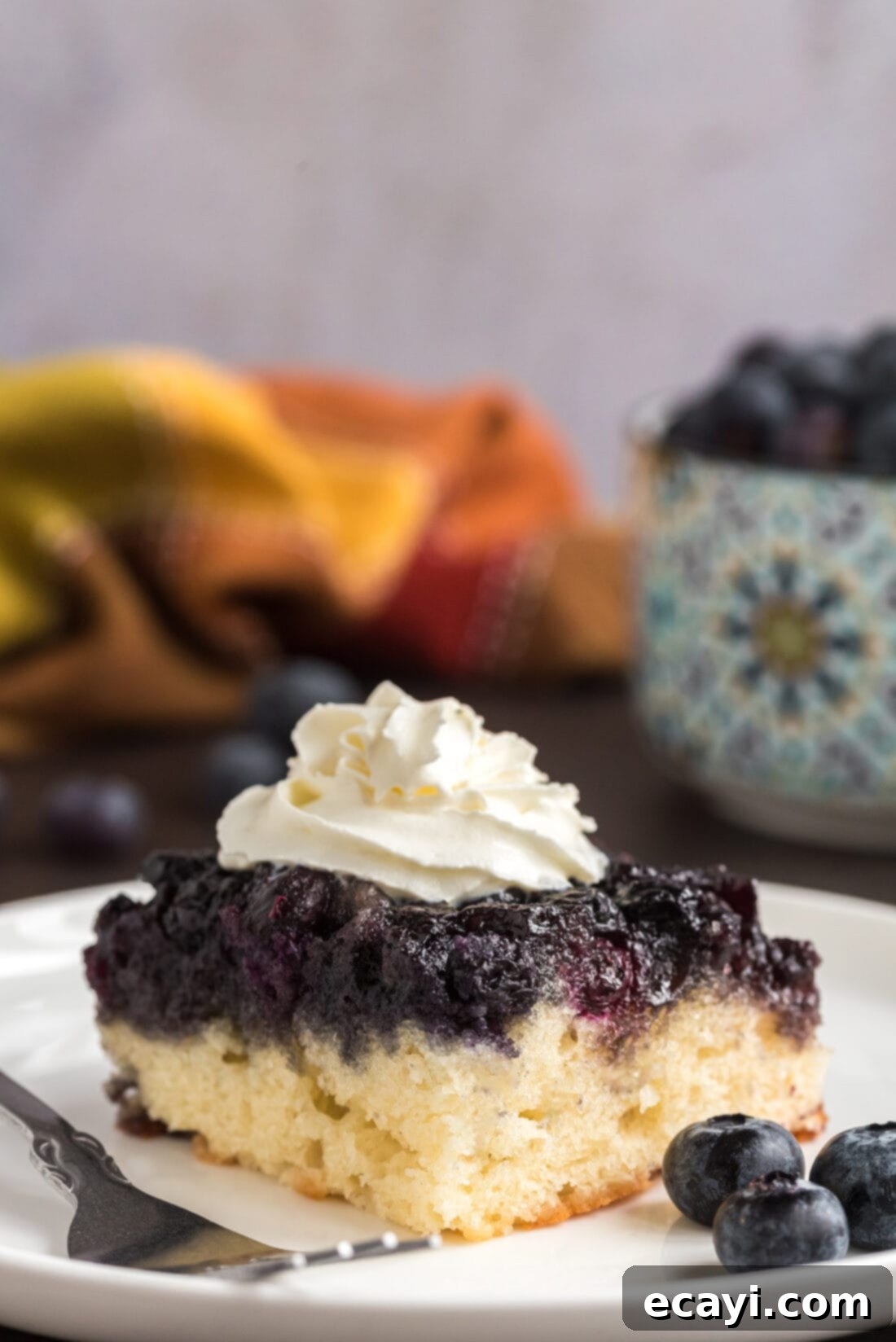 Blueberry Flip Cake 3 Piece of Easy Blueberry Upside Down Cake on a plate topped with whipped cream