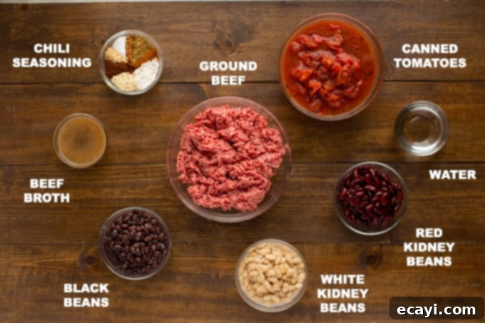 This 3 Bean Chili is made with a homemade chili seasoning, fresh ground beef, fire roasted tomatoes, and three types of canned beans. Great for football!  A vibrant selection of fresh and canned ingredients, including various beans, ground beef, and tomatoes, neatly arranged for 3 Bean Chili preparation.