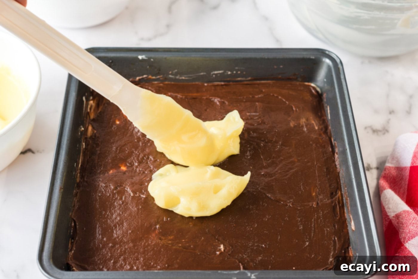 Ultimate Pan Indulgence 11 Vanilla pudding being dolloped on top of the chocolate pudding layer