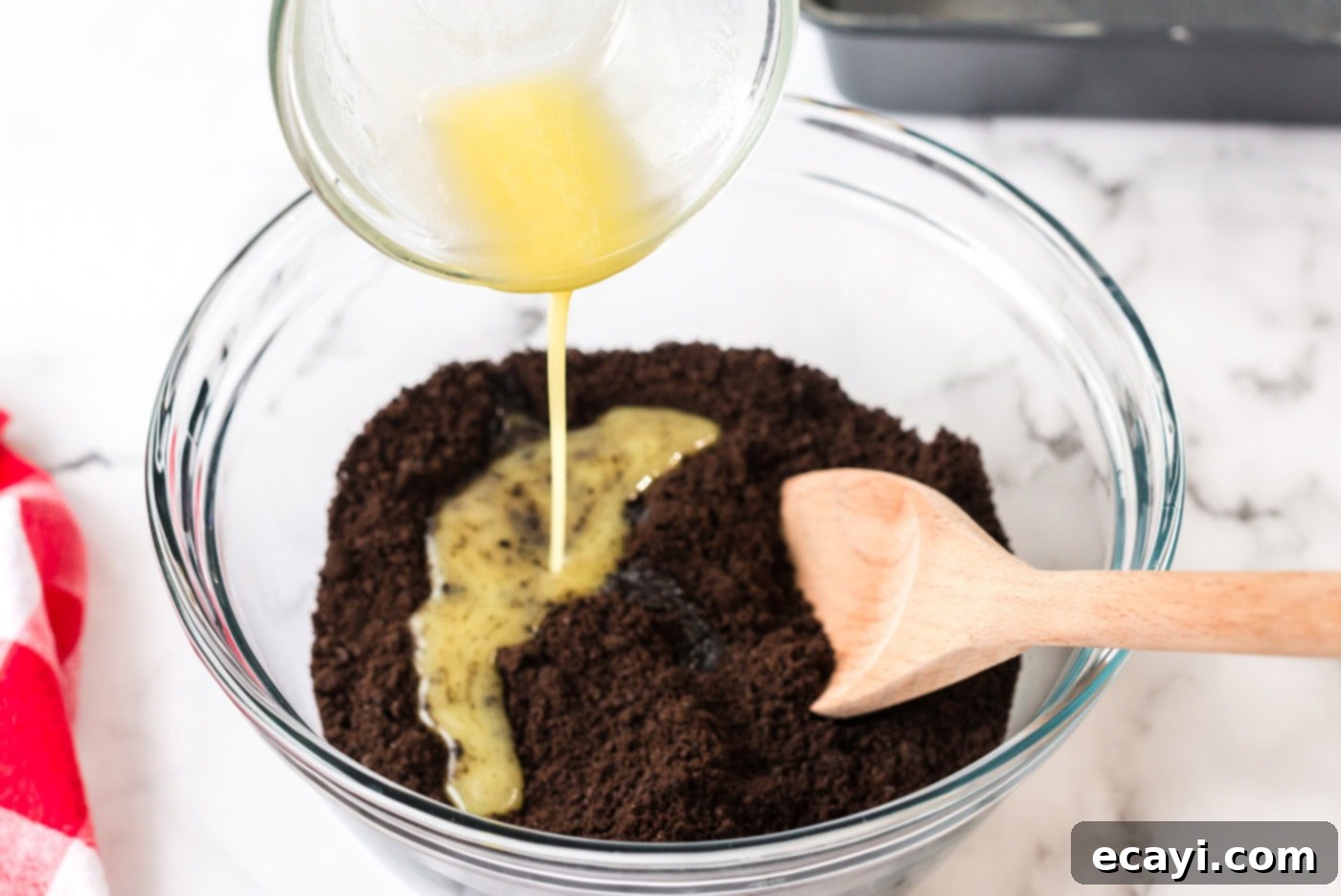 Ultimate Pan Indulgence 5 Butter being poured into oreo crumbs