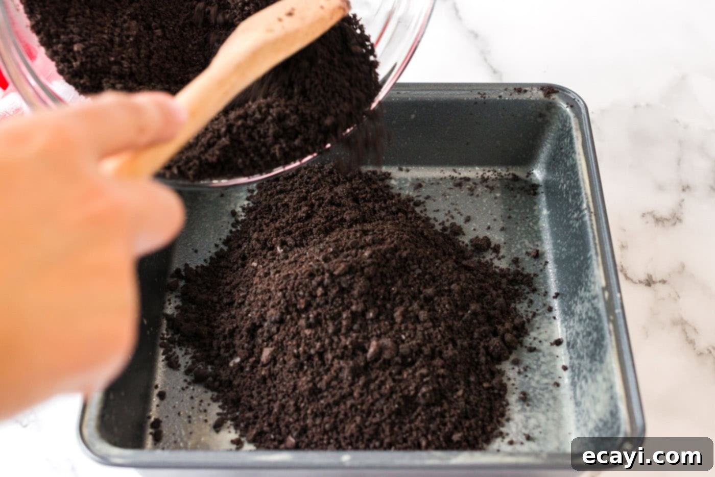 Ultimate Pan Indulgence 6 Crumb mixture being poured into a pan