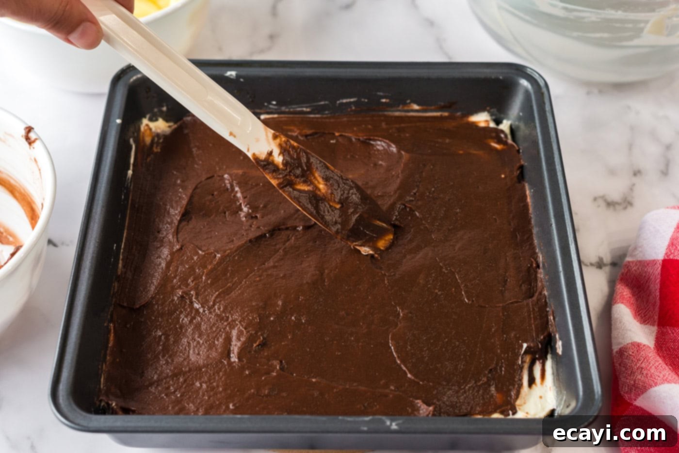 Ultimate Pan Indulgence 10 Chocolate pudding being spread over the cream cheese mixture