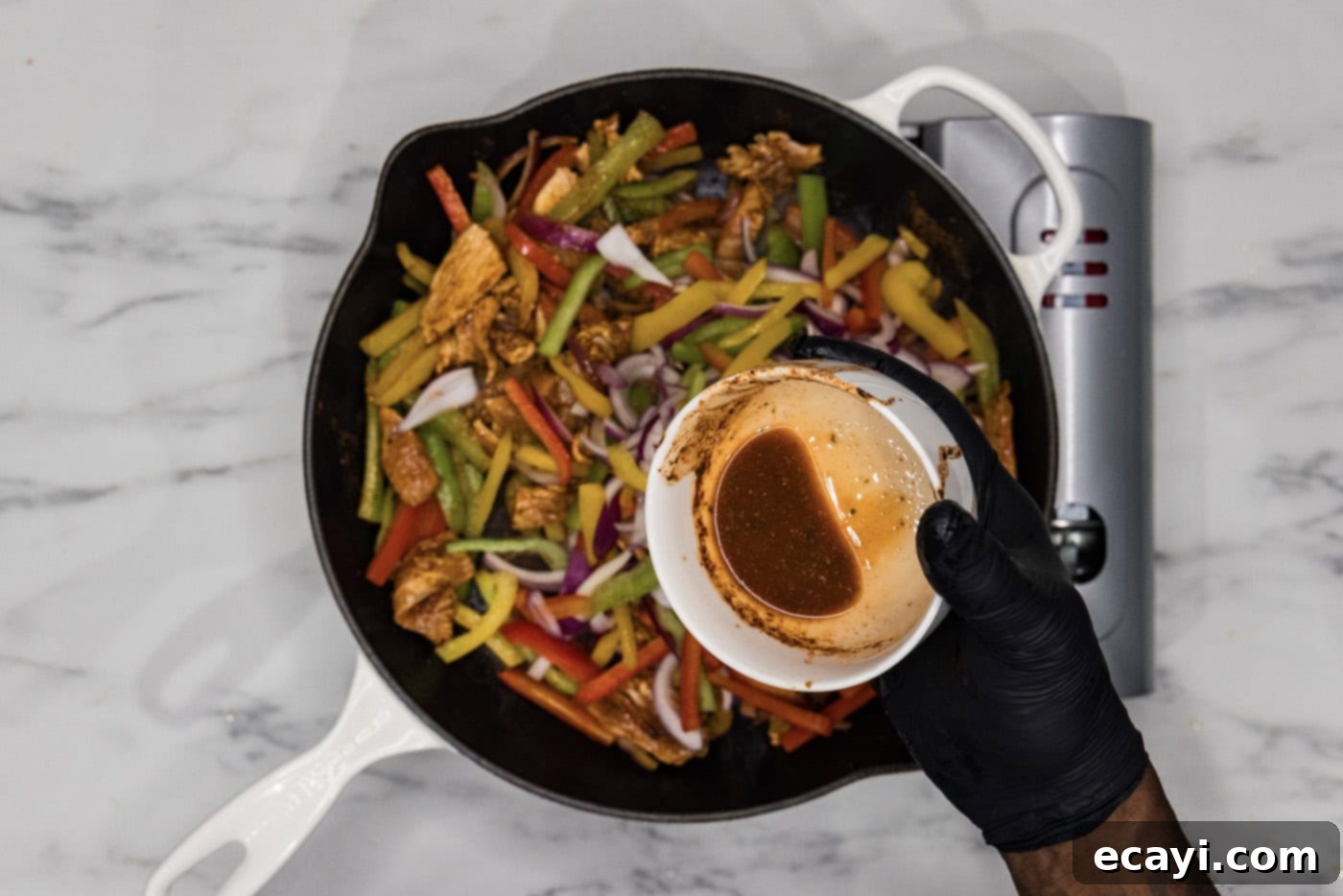 Sizzling Chicken Fajitas 7 pouring remaining marinade into skillet with chicken fajitas