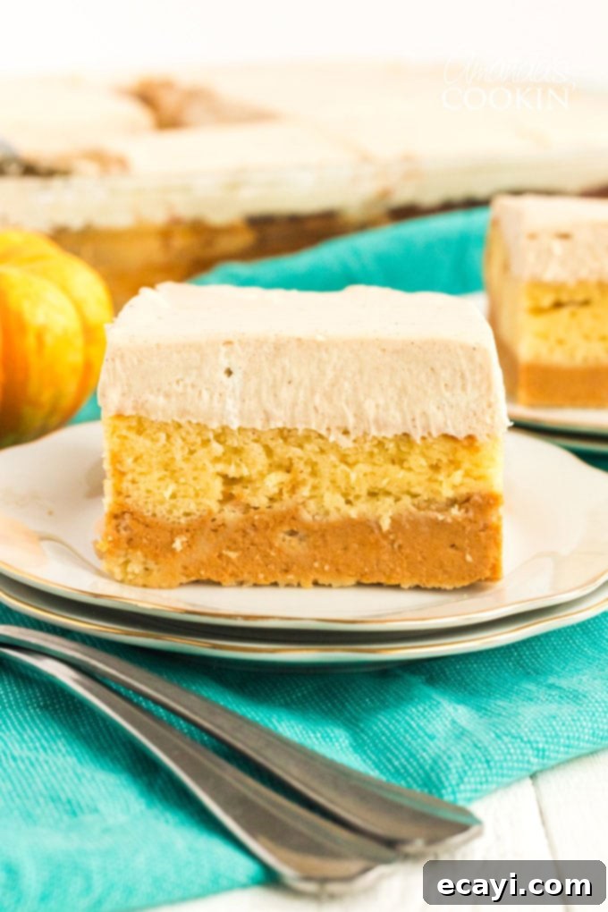 Discover the magic of this layered pumpkin cake, an easy doctored cake mix recipe perfect for fall. Beautifully layered pumpkin magic cake on a white plate, ready to be enjoyed as a fall dessert.