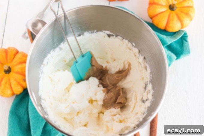 Spiced Pumpkin Magic Cake 9 Gently folding the pudding mixture into the whipped cream with a rubber spatula to create a light and fluffy topping.