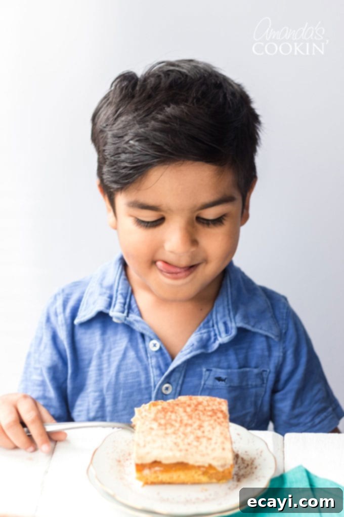This easy Pumpkin Magic Cake recipe is so delicious, even the kids will be eagerly waiting for a slice! A young boy excitedly licking his lips, anticipating a slice of the delicious Pumpkin Magic Cake.