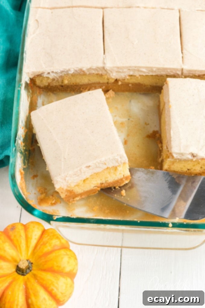 Experience the magic of this pumpkin cake, featuring a convenient doctored cake mix and stunning layers. A pan of delicious pumpkin magic cake with a slice being removed, showing the distinct layers.