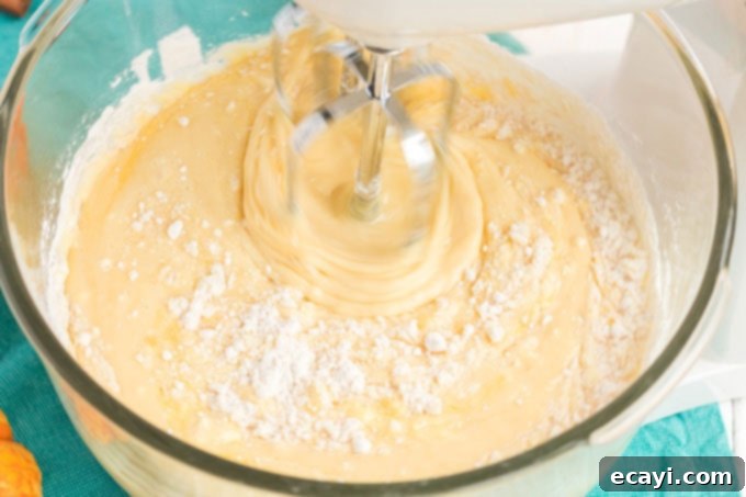 Spiced Pumpkin Magic Cake 2 Mixing the yellow cake batter in a bowl, a crucial first step for the pumpkin magic cake.
