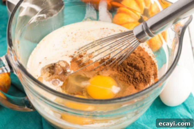 Spiced Pumpkin Magic Cake 4 Bowl filled with ingredients for the pumpkin pie layer, ready to be whisked into a smooth mixture.