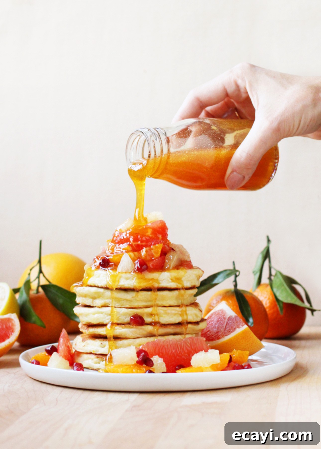 Zesty Ricotta Pancakes with Golden Citrus Drizzle 3 Close-up of fluffy Citrus Ricotta Pancakes drizzled with homemade citrus syrup, ready for a delicious breakfast.