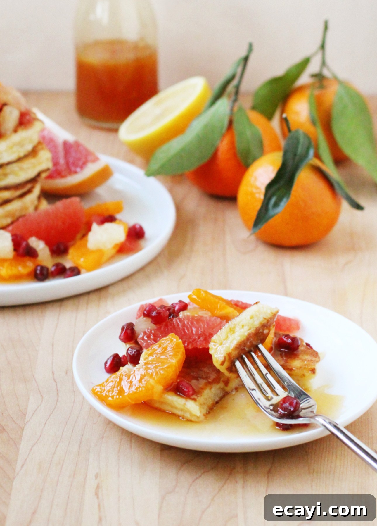 Zesty Ricotta Pancakes with Golden Citrus Drizzle 8 A generous serving of fluffy Citrus Ricotta Pancakes, artfully garnished with various citrus slices and a delicate drizzle of homemade syrup.