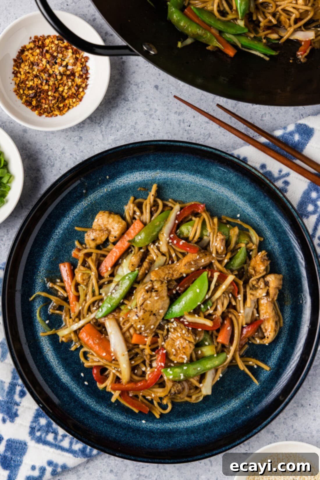 Classic Chicken Lo Mein 2 Plate of Chicken Lo Mein with tender noodles, colorful vegetables, and savory sauce, ready to be enjoyed, with a wok in the background.