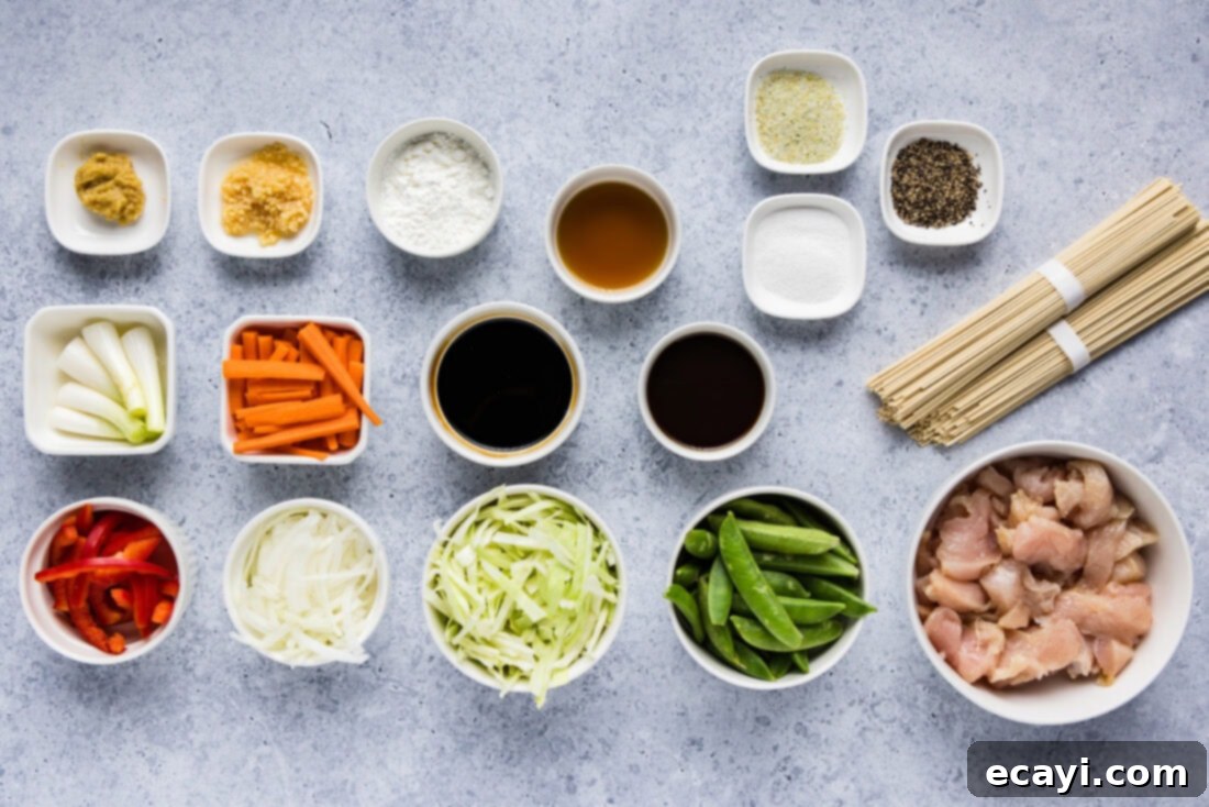 Classic Chicken Lo Mein 4 A selection of fresh ingredients laid out, including chicken, various chopped vegetables, and sauces, ready for making lo mein.