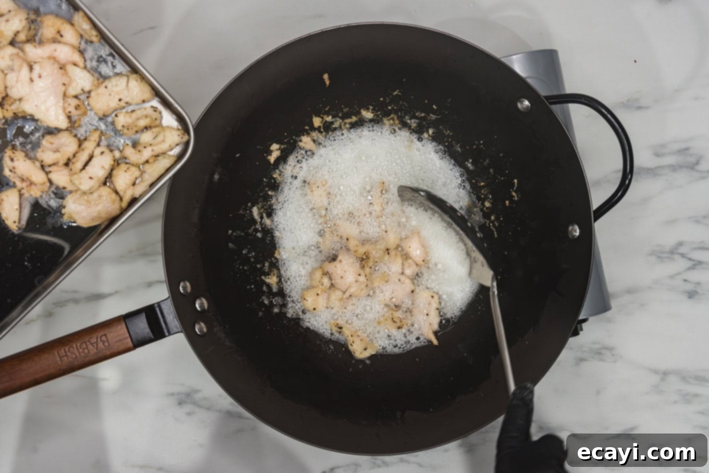 Classic Chicken Lo Mein 6 removing cooked chicken from a wok of hot oil with a slotted spoon