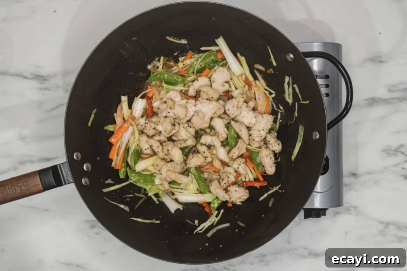Classic Chicken Lo Mein 8 cooked chicken pieces added to a wok with stir-fried vegetables, ready for the sauce