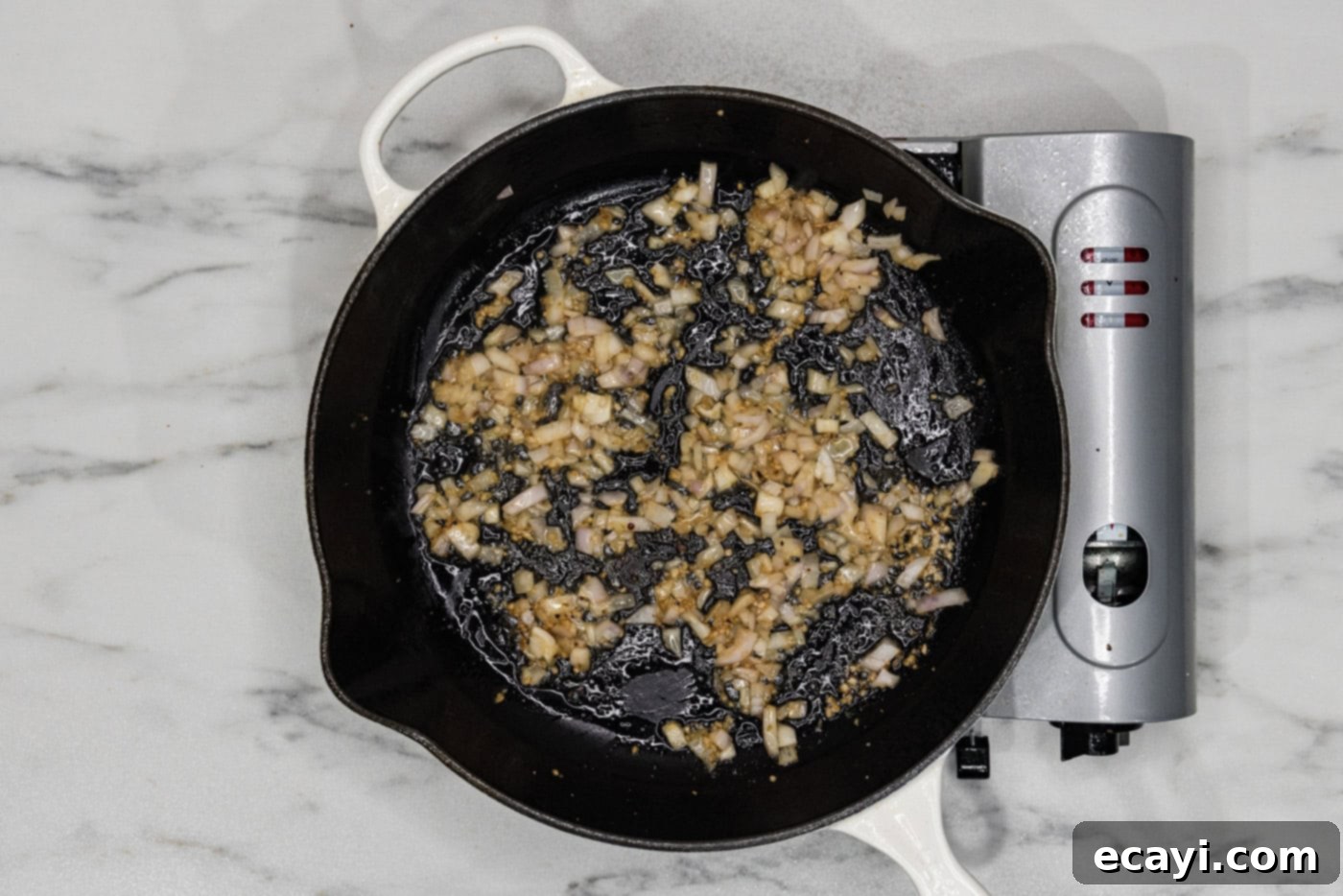 Sun-Kissed Tuscan Chicken 6 Minced garlic and chopped shallots cooking in butter in a skillet, releasing their aroma.