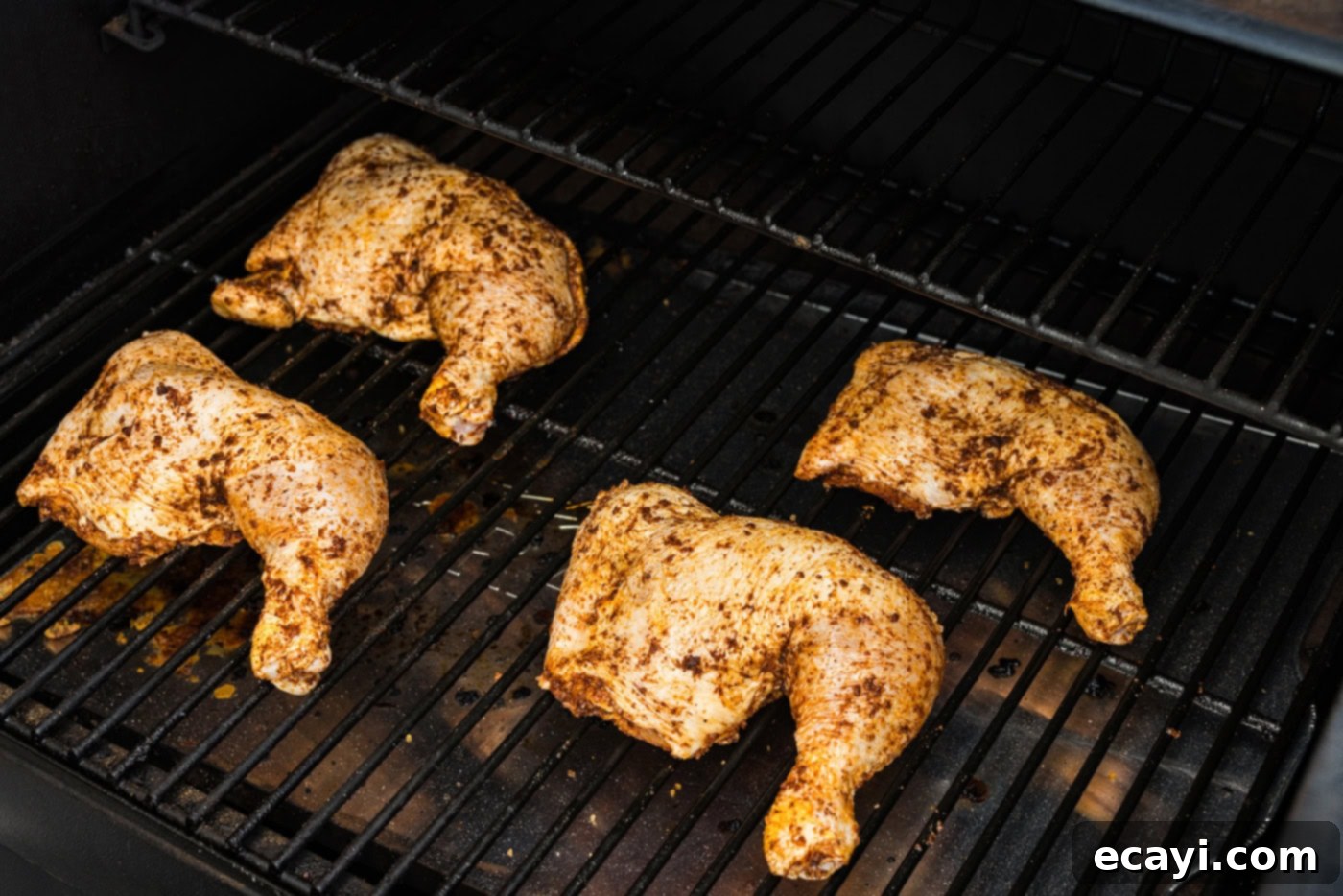 Juicy Smoked Chicken Quarters 6 photo of seasoned chicken quarters on smoker grill grates