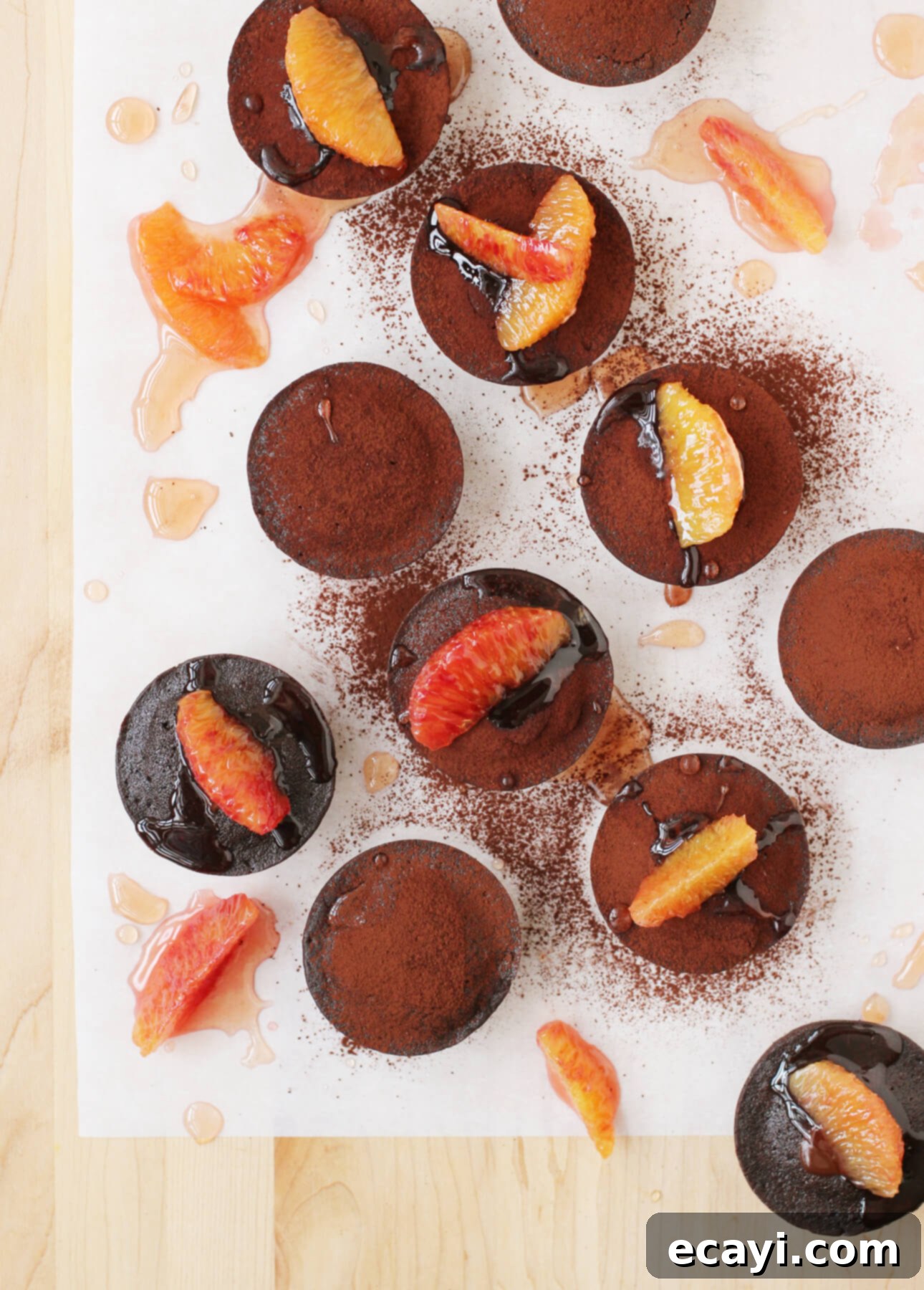 Decadent Blood Orange Chocolate Lava Cakes 2 Rich dark chocolate fondant cakes topped with vibrant blood orange segments and syrup, presented elegantly.