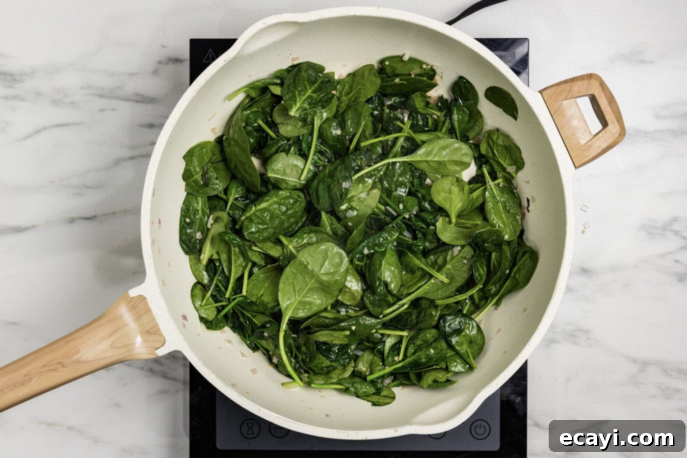 Vibrant Spinach Spaghetti 5 Fresh spinach leaves being added to a skillet with butter, garlic, and shallots.