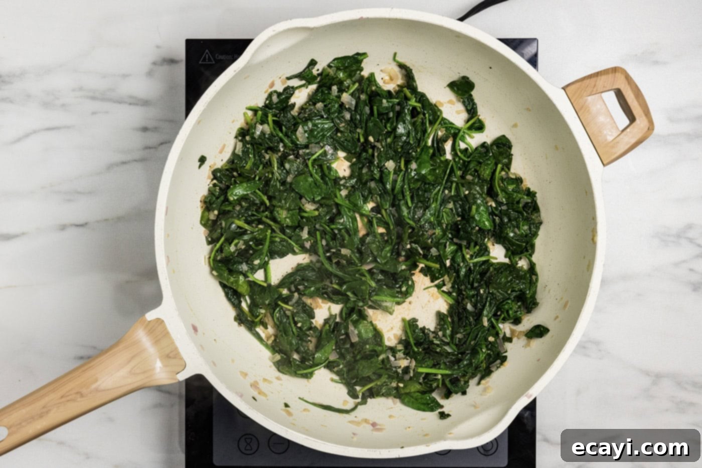 Vibrant Spinach Spaghetti 7 The fully sautéed spinach mixture in a skillet, ready for blending.