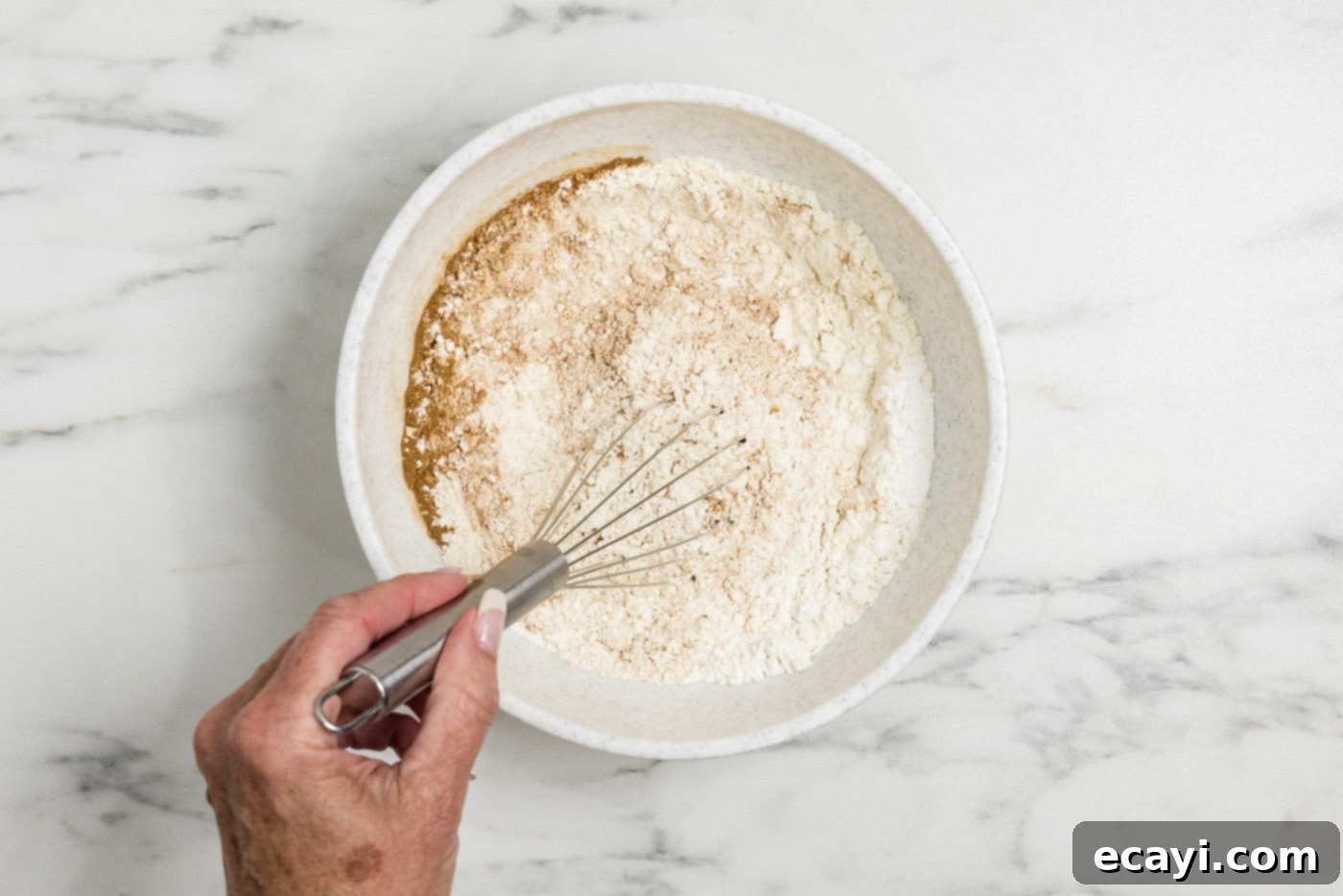 Spiced Apple Muffins 5 hand whisking dry ingredients in a bowl
