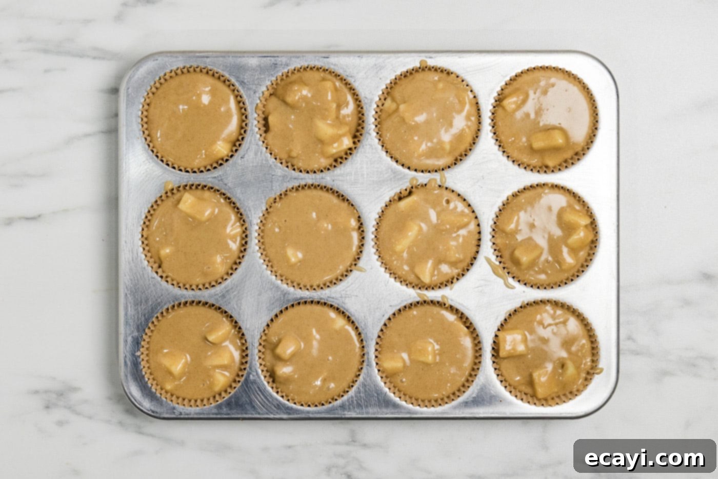 Spiced Apple Muffins 8 apple muffin batter in a muffin tin