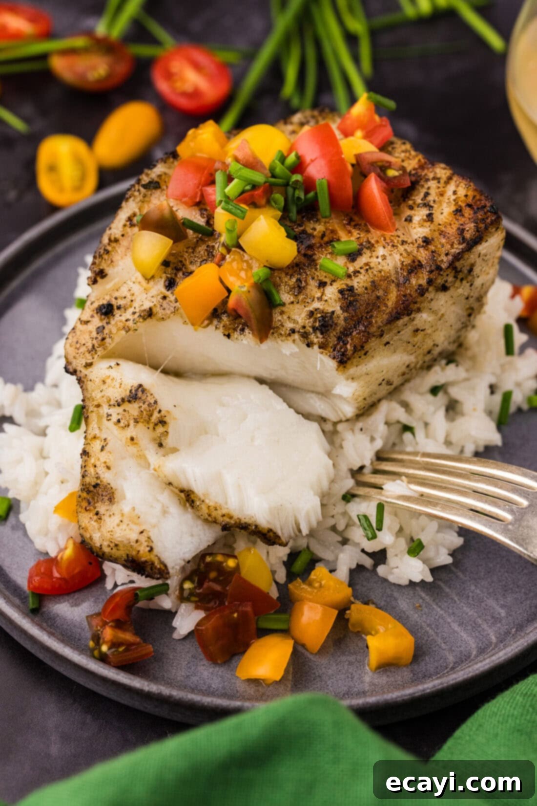 Buttery Grilled Chilean Sea Bass 2 Perfectly grilled Chilean sea bass fillet, flaked apart over a bed of white rice, showcasing its tender texture